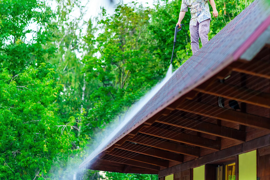 a man is spraying water on a roof