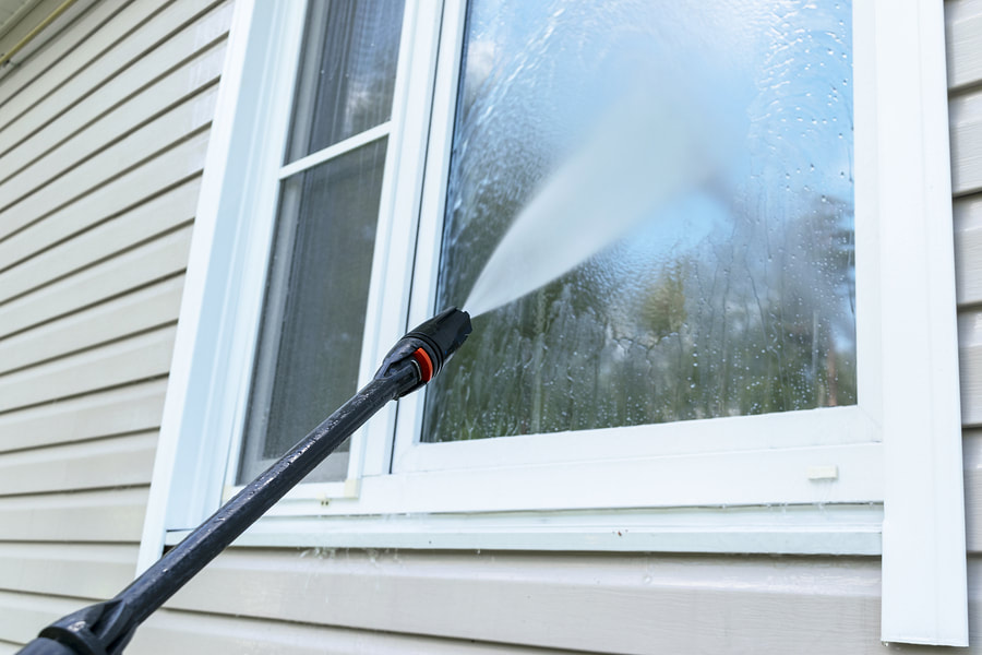 a window cleaning a house with a high pressure mop