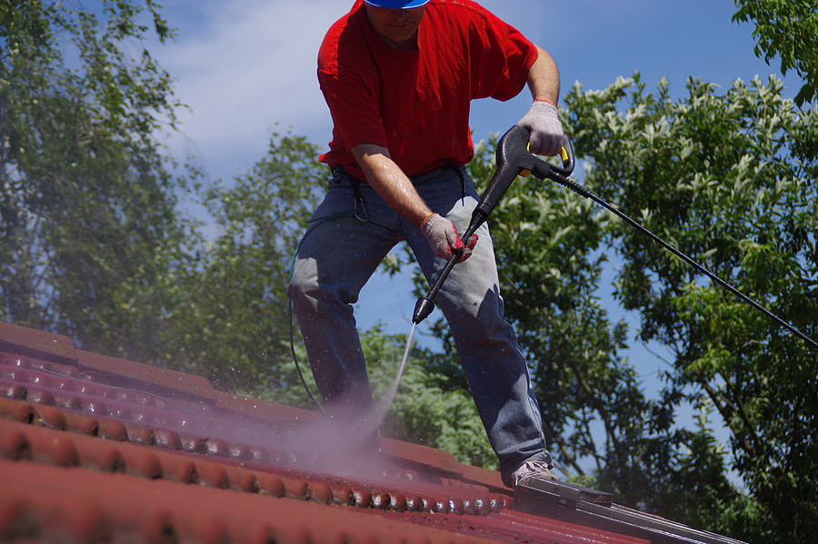 a man in a red shirt and blue hat is using a power tool